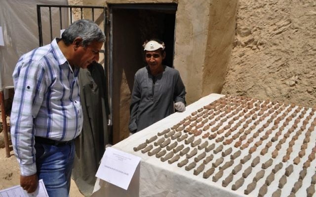 A member of an Egyptian archaeological team, right, stands near artifacts, known as Ushabtis, discovered in a 3,500-year-old tomb in the Draa Abul Nagaa necropolis, near the southern city of Luxor, April 18, 2017. (AFP/STRINGER) A member of an Egyptian archaeological team, right, stands near artifacts, known as Ushabtis, discovered in a 3,500-year-old tomb in the Draa Abul Nagaa necropolis, near the southern city of Luxor, April 18, 2017. (AFP/STRINGER)