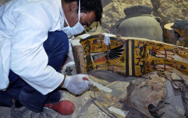 An archaeologist works on a wooden coffin discovered in a 3,500-year-old tomb in the Draa Abul Nagaa necropolis, near the southern Egyptian city of Luxor, on April 18, 2017. (AFP PHOTO / STRINGER)