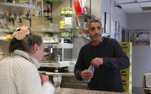 French bar owner Amar Salhi serves a customer at his bar in Sevran, northeast of Paris, April 13, 2017. (AFP/Adam PLOWRIGHT)