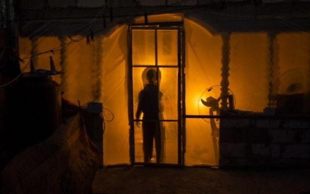The silhouette of Palestinian boy is seen on their makeshift home in the Khan Yunis refugee camp in the southern Gaza Strip on April 19, 2017. (Mahmud Hums/AFP) The silhouette of Palestinian boy is seen on their makeshift home in the Khan Yunis refugee camp in the southern Gaza Strip on April 19, 2017. (Mahmud Hums/AFP)