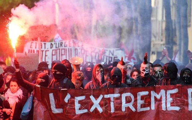 Demonstrators march behind a banner as they stage a protest against the far-right Front National (FN) in Marseille on April 19, 2017 (AFP PHOTO / SYLVAIN THOMAS)