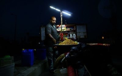 A Palestinian street vendor waits for customers during a power cut in Gaza City, on April 20, 2017. (AFP Photo/Mohammed Abed) A Palestinian street vendor waits for customers during a power cut in Gaza City, on April 20, 2017. (AFP Photo/Mohammed Abed)