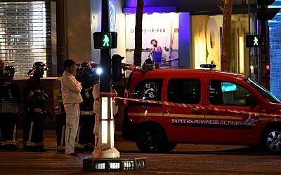 Firefighters and rescuers stand by the site of a shooting on the Champs Elysees in Paris on April 20, 2017. (AFP Photo/Franck Fife)