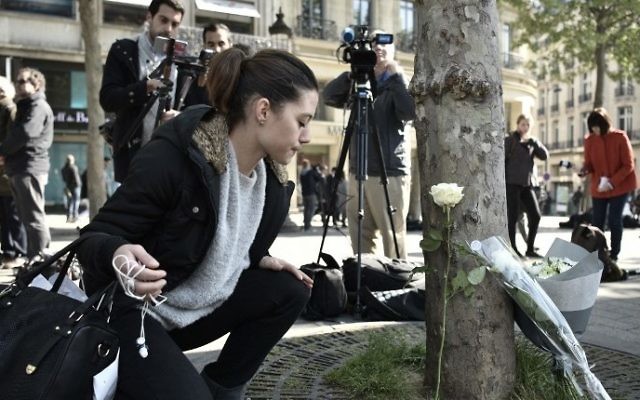 A woman places a flower at the spot where a shooting occured on the Champs-Elysees avenue in Paris, on April 21, 2017 a day after a gunman opened fire on police on the avenue, killing a policeman and wounding two others in an attack claimed by the Islamic State group. (Pilippe Lopez/AFP) A woman places a flower at the spot where a shooting occured on the Champs-Elysees avenue in Paris, on April 21, 2017 a day after a gunman opened fire on police on the avenue, killing a policeman and wounding two others in an attack claimed by the Islamic State group. (Pilippe Lopez/AFP)