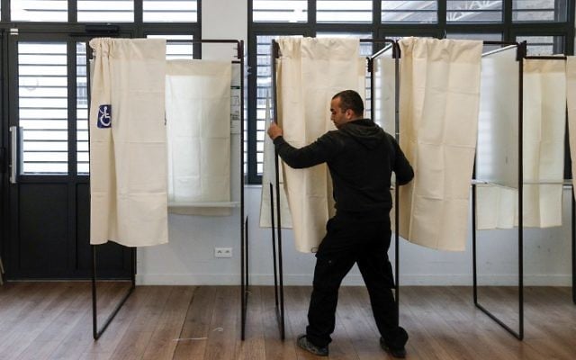 A municipal employee prepares a polling station, on April 22, 2017 in Montreuil, near Paris, on the eve of the French presidential election's first round. (AFP PHOTO / GEOFFROY VAN DER HASSELT)