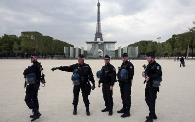 French policemen stand in front of the Eiffel tower in Paris on April 22, 2017. (AFP/Geoffroy van der Hasselt)
