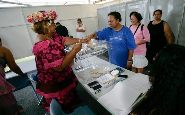 A woman casts her ballot as part of the vote for the first round of the French presidential elections, on April 22, 2017 in Papeete, the capital of the French Polynesian island of Tahiti. (AFP PHOTO / Gregory BOISSY)