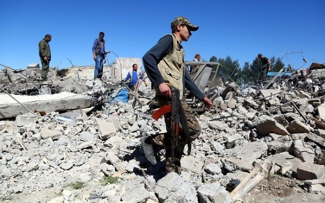 Fighters from the Kurdish People's Protection Units (YPG) visit the site of Turkish airstrikes near northeastern Syrian Kurdish town of Derik, known as al-Malikiyah in Arabic, on April 25, 2017. (AFP PHOTO / DELIL SOULEIMAN)