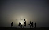 Palestinian youths play volleyball as the sun sets in Gaza City, on April 26, 2017. / AFP PHOTO / MOHAMMED ABED