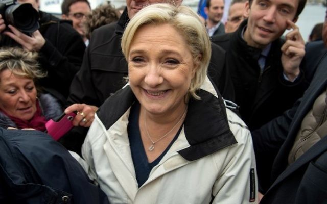 French presidential candidate for the far-right Front National party Marine Le Pen (C) walks past supporters in the harbor of Le Grau-du-Roi, southern France, on early April 27, 2017. (AFP Photo/Bertrand Langlois)
