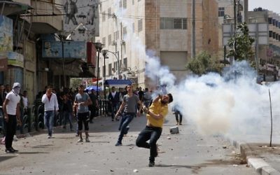 Palestinian protesters throw stones in the West Bank city of Hebron on April 27, 2017, during clashes with Israeli soldiers as a trade strike in support of Palestinian prisoners on hunger strike in Israeli jails takes place. (AFP/Hazem Bader)