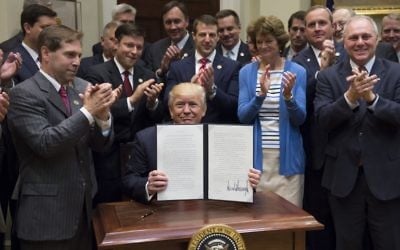 US President Donald Trump holds up an executive order on Implementing an America-First Offshore Energy Strategy after signing it in the Roosevelt Room of the White House in Washington, DC, April 28, 2017. (AFP PHOTO / SAUL LOEB)