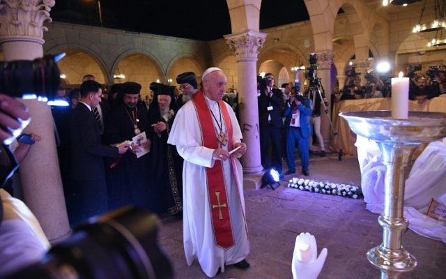 Pope Francis (C) prepares to light a candle during a visit at the Saint Peter and Saint Paul church in Cairo, which was target by a suicide bomb attack that killed 29 people last December, on April 28, 2017. (Andreas Solaro/AFP)