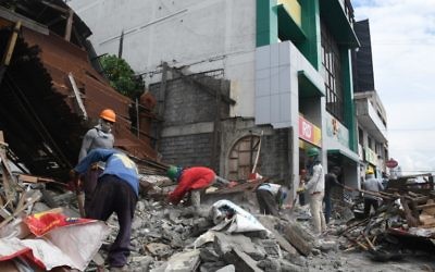 Workers remove debris from a collapsed house after a 6.8-magnitude earthquake hit General Santos City, in southern island of Mindanao on April 29, 2017. (AFP/Edwin Espejo)