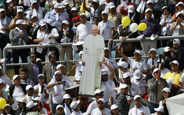 Worshipers hold a cardboard cut-out of Pope Francis before the start of a mass on April 29, 2017 at a stadium in Cairo. ( AFP PHOTO / Andreas SOLARO)