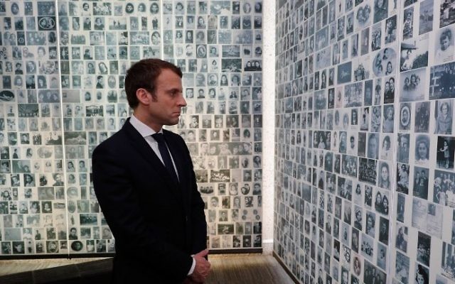 French presidential candidate Emmanuel Macron looks at some of the 2,500 photographs of young Jews deported from France during the WWII Nazi occupation, during a visit to the Shoah Memorial on April 30, 2017 in Paris. (AFP PHOTO / POOL / PHILIPPE WOJAZER)
