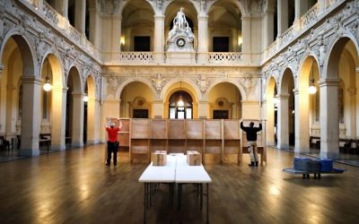 Workers prepare voting booths at a polling station in Lyon, central France, Saturday, April 22, 2017. The two-round presidential election will take place on April 23 and May 7. (AP Photo/Laurent Cipriani)