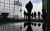 People enter the Sachsenhausen Nazi death camp through the gate with the inscription 'Arbeit macht frei' (work sets you free) for commemorations for the 72nd anniversary of the liberation of the camp in Oranienburg, about 35 kilometer north of Berlin, April 23, 2017. (AP/Markus Schreiber)