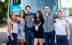 Noa Tnua founder Roy Schwartz Tichon, second from right, and board member Noam Tel-Verem, third from right, posing with volunteers before the launch of their bus service in Ramat Gan, Israel, June 6, 2015. (Avihai Levy)