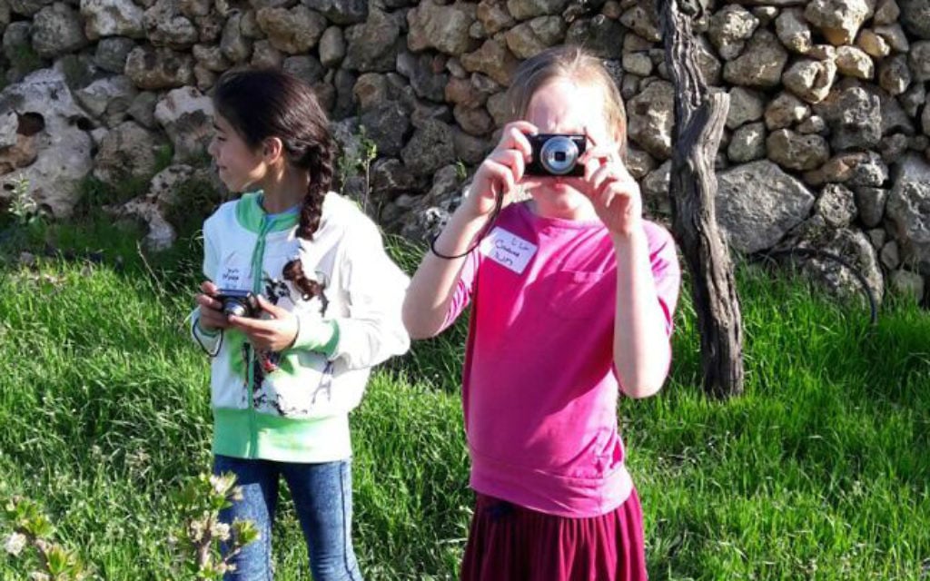 Young Israeli and Palestinian girls take photos together in Ard, as part of the Roots coexistence initiative. (Brett Kline/Times of Israel) Young Israeli and Palestinian girls take photos together in Ard, as part of the Roots coexistence initiative. (Brett Kline/Times of Israel)