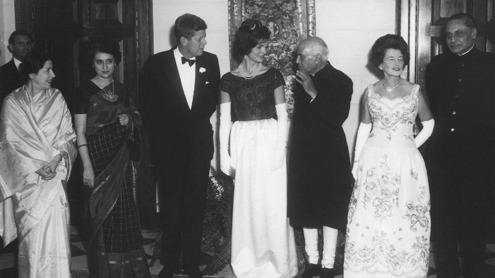 A dinner at the Indian Embassy in Washington DC. (L-R): Shobha Nehru; Indira Gandhi; US president Kennedy; first lady Jacqueline Kennedy; Indian prime minister Jawaharlal Nehru; Rose Kennedy; and Indian ambassador BK Nehru. (Public domain, White House, Wikimedia Commons)