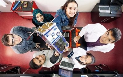 Participating high school students hold up the Duchifat-2 nanosatellite that was launched into space from the Kennedy Space Center, Cape Canaveral, Florida, April 18, 2017. (Israel Space Agency/Roi Greenberg)