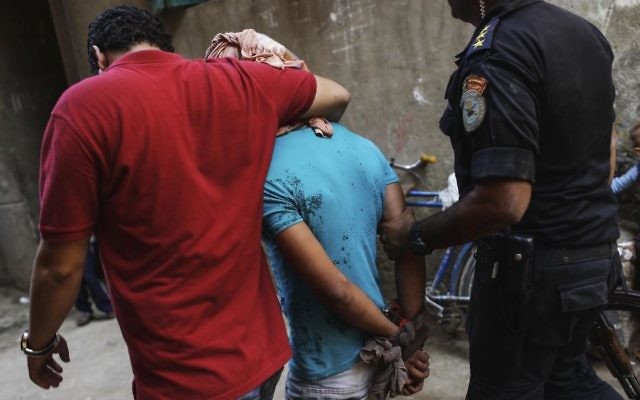 In this Sept. 26, 2013 file photo, Egyptian security forces detain a man in Giza's Kerdasa district, south of Cairo, Egypt. (AP Photo/Eman Helal, File)