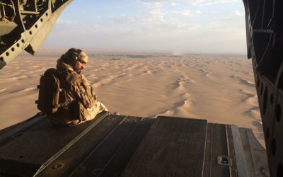 In this Sept. 17, 2015 photo, an Emirati gunner watches for enemy fire from the rear gate of a United Arab Emirates Chinook military helicopter flying over Yemen. . (AP Photo/Adam Schreck)