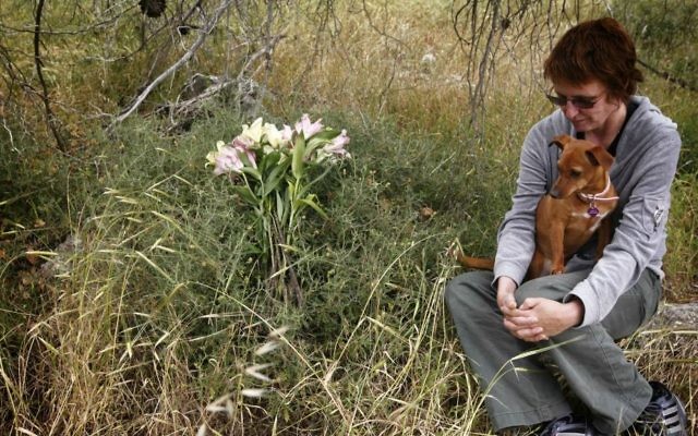 Kay Wilson, who survived a stabbing attack as she was hiking in the forest near Jerusalem a few months ago, sits with her dog Peanut at the site of the stabbing, April 21, 2011. Wilson's friend Kristine Luken was killed in the attack which was committed by Ayad Fatafta and Kifah Ghanimat on December 18, 2010. (Miriam Alster/FLASH90)