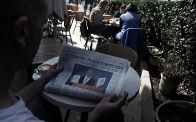 A man reads a copy of the Haaretz daily at a cafe in Jerusalem on March 7, 2012. (Kobi Gideon/Flash90)