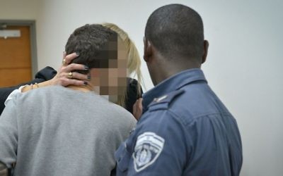 A teenage Israeli hacker, suspected of  sending false threats of terror attacks to Jewish facilities across the world, is brought to the Rishon Lezion Magistrate's Court, March 30, 2017. (Flash90)
