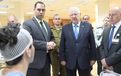 President Reuven Rivlin visits wounded Syrians being treated at a hospital in the northern city of Nahariya on April 9, 2017. (Amos Ben Gershom/GPO)