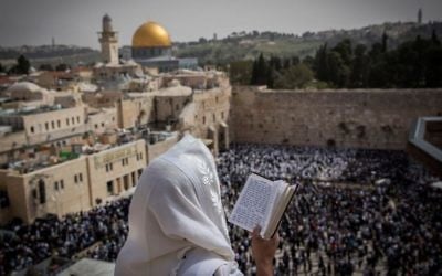 Illustrative: A Jewish man covers himself with a prayer shawl while praying near the Western Wall in Jerusalem's Old City during the Passover priestly blessing on April 13, 2017. (Yonatan Sindel/Flash90)