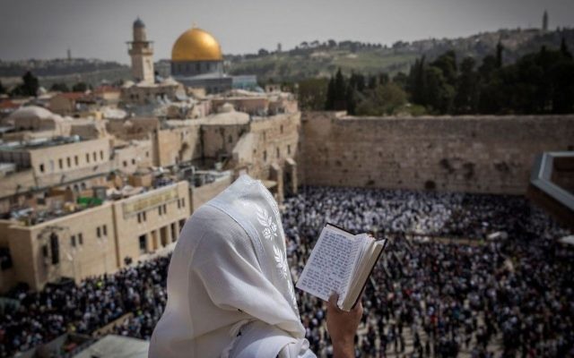 Illustrative: A Jewish man covers himself with a prayer shawl while praying near the Western Wall in Jerusalem's Old City during the Passover priestly blessing on April 13, 2017. (Yonatan Sindel/Flash90) Illustrative: A Jewish man covers himself with a prayer shawl while praying near the Western Wall in Jerusalem's Old City during the Passover priestly blessing on April 13, 2017. (Yonatan Sindel/Flash90)