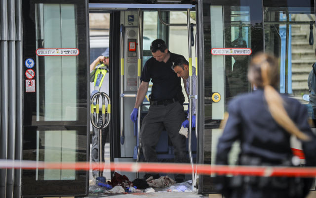 Police collect evidence at the scene of a stabbing attack on the Jerusalem light rail near IDF Square in the capital on April 14, 2017. (Yonatan Sindel/FLASH90) Police collect evidence at the scene of a stabbing attack on the Jerusalem light rail near IDF Square in the capital on April 14, 2017. (Yonatan Sindel/FLASH90)