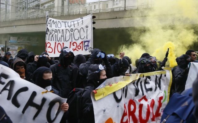 Protesters against far-right National Front leader and presidential candidate Marine Le Pen hold a banner reading 'fascist' during a protest march from suburban Aubervilliers to Paris, Sunday, April 16, 2017. (AP/Francois Mori)