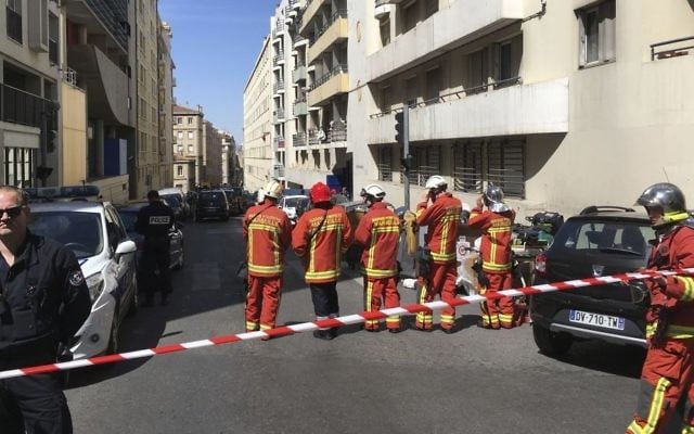 A police officer and rescue workers cordon off a street during searches in Marseille, southern France on April 18, 2017 after French police thwarted an imminent "terror attack." (AP Photo/Claude Paris) 