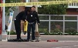 Fresno police stand next to a pile of clothes in front of a corner market in the neighborhood where shootings occurred in Fresno, Calif., Tuesday, April 18, 2017. (AP/Scott Smith)
