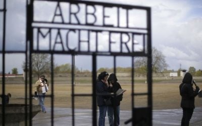 People stand behind the gate with the inscription 'Arbeit macht frei' (work sets you free) at the Sachsenhausen Nazi death camp in Oranienburg, about 35 kilometers north of Berlin, April 23, 2017. Commemorations will be held on Sunday on the occasion of the 72th anniversary of the liberation of the camp. (AP/Markus Schreiber)