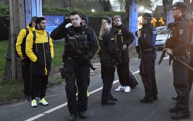 Dortmund's Marcel Schmelzer talks to police officers outside the team bus after it was damaged in an explosion before the Champions League quarterfinal soccer match between Borussia Dortmund and AS Monaco in Dortmund, Germany, April 11, 2017. (AP Photo/Martin Meissner)