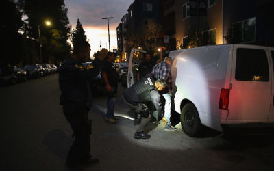 A man is detained by Immigration and Customs Enforcement agents in Los Angeles, Oct. 14, 2015. (John Moore/Getty Images)