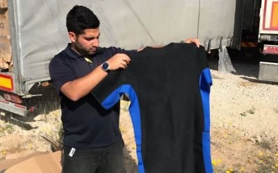 A Defense Ministry worker displays a wet suit found hidden in a shipment of sporting gear that was bound for the Gaza Strip on April 3, 2017. (Defense Ministry)
