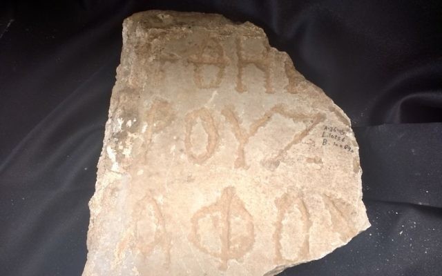 Part of an ancient Greek inscription found during excavations at Caesarea, Israel, April 2017. (Ilan Ben Zion/Times of Israel)