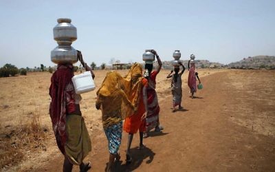 Women returning home after collecting water from a well in Dolhare, India, May 10, 2012. (Mahendra Parikh/Hindustan Times via Getty Images, via JTA)