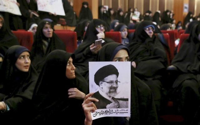 An Iranian holds up a poster of Iranian cleric Ebrahim Raisi, a conservative presidential candidate in the upcoming presidential election, at a campaign rally in Tehran, Iran, Wednesday, April 26, 2017. (AP Photo/Ebrahim Noroozi) An Iranian holds up a poster of Iranian cleric Ebrahim Raisi, a conservative presidential candidate in the upcoming presidential election, at a campaign rally in Tehran, Iran, Wednesday, April 26, 2017. (AP Photo/Ebrahim Noroozi)