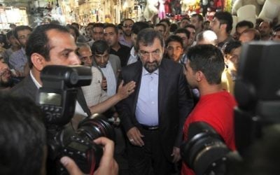 In this file photo taken on Tuesday, May 28, 2013, Iranian presidential candidate Mohsen Rezaei, center, walks through the old main bazaar of Tehran. (AP Photo/Vahid Salemi, File)