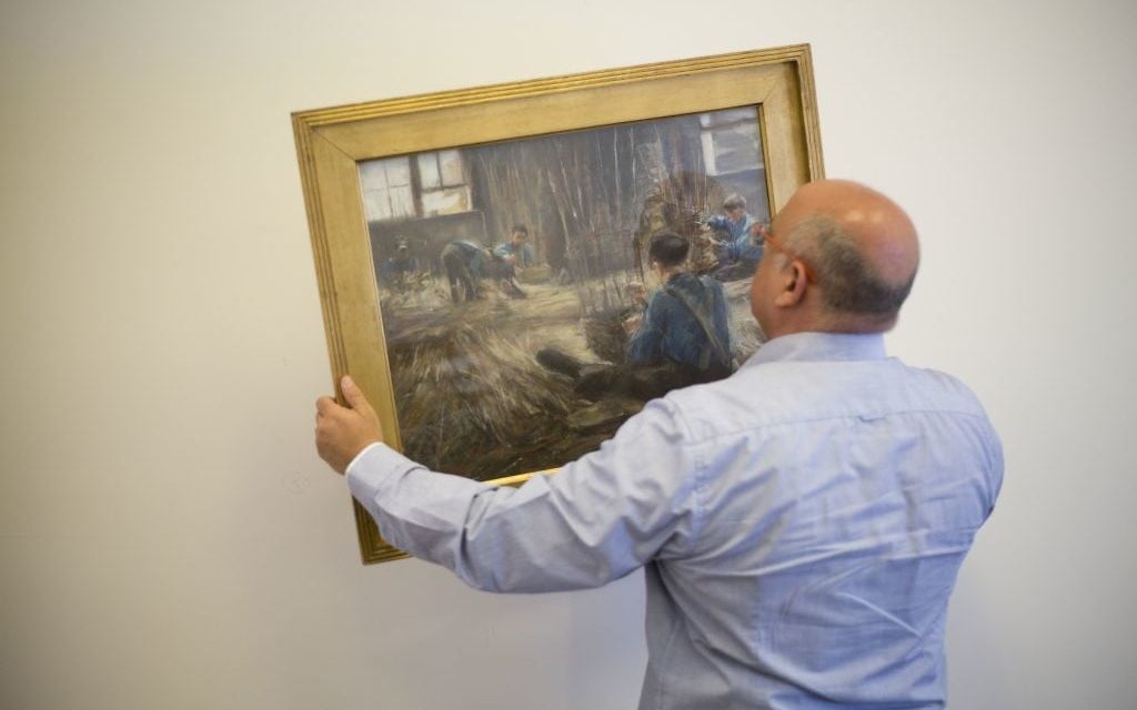 In this photo taken on Wednesday, April 5, 2017, Meir Heller, the Jerusalem lawyer, whose client insists on maintaining his anonymity, holds the Max Liebermann's 'Basket Weavers' painting in a law office in Jerusalem, Wednesday, April 5, 2017. (AP Photo/Ariel Schalit) In this photo taken on Wednesday, April 5, 2017, Meir Heller, the Jerusalem lawyer, whose client insists on maintaining his anonymity, holds the Max Liebermann's 'Basket Weavers' painting in a law office in Jerusalem, Wednesday, April 5, 2017. (AP Photo/Ariel Schalit)