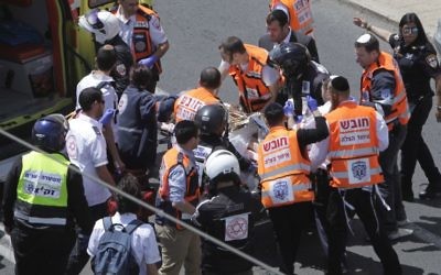 Emergency services evacuate an injured person from the scene of an stabbing attack in Jerusalem Friday, April 14, 2017. Israeli police said a Palestinian man stabbed a woman in Jerusalem, seriously wounding her before forces apprehended him at the scene. She later died. (AP Photo/Mahmoud Illean)