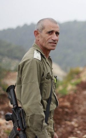 Maj. Eliyahu Gabay stands on a berm near the Lebanese border at kibbutz Hanita on March 22, 2017. (Judah Ari Gross/Times of Israel)