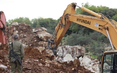 Maj. Eliyahu Gabay speaks with workers creating a berm near the Lebanese border at kibbutz Hanita on March 22, 2017. (Judah Ari Gross/Times of Israel)